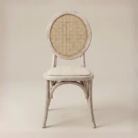 Silla Marian de madera de pino con respaldo en bejuco sintético y asiento tapizado. Ideal para interiores.