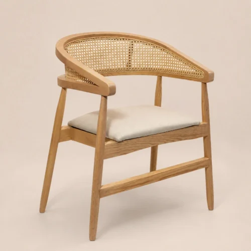 Silla Praga de madera de pino con respaldo semicircular de bejuco y asiento tapizado.