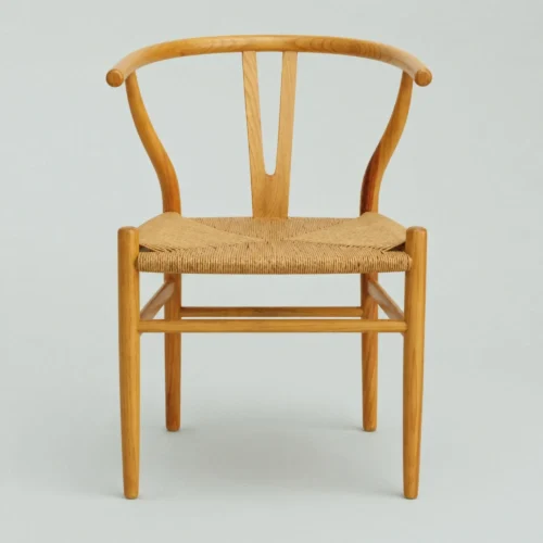 Silla Wishbone de madera de pino, con asiento tejido con celulosa natural.